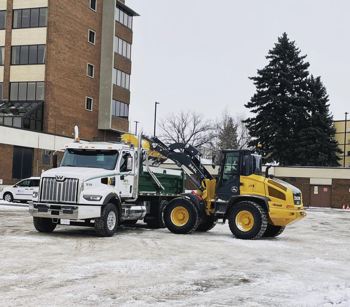 Avara snow and ice management fleet — plow truck and loader on-site in Medicine Hat